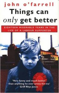 The cover of a book by John O'Farrell - Things can only get better. Sad looking boy in blue with a red rosette on, stood in front of a factory 